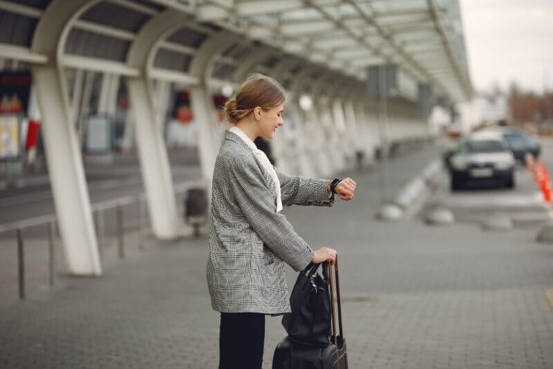 Woman With Suitcase Standing By Airport